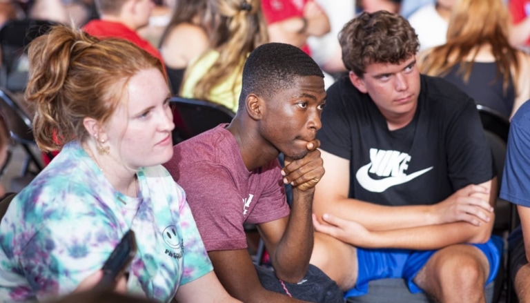 A seated group of young visitors engaged in listening.