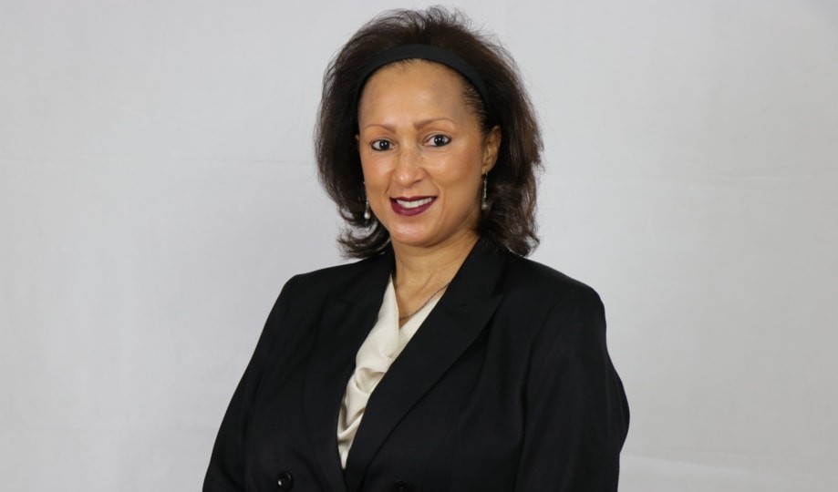 Portrait photo of a woman in a black business jacket and beige top