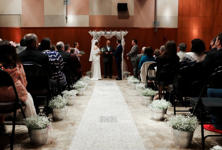 A wedding ceremony in process with a seated audience
