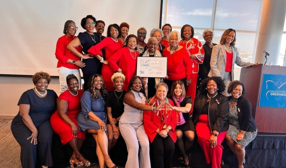 A group of women all dressed in red posing with an award