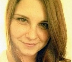 Woman with white shirt smiles for camera on bright background