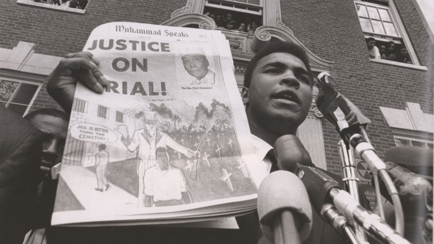 Muhammad Ali holds up a newspaper reading "Justice on Trial!"