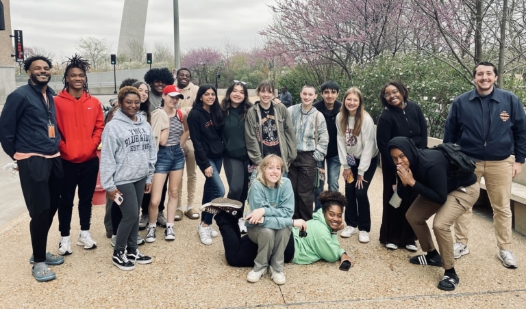 Two Ali Center staff members and a group of teens standing outside