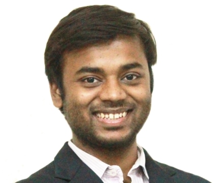Man wearing black jacket and white button-up shirt smiles for camera