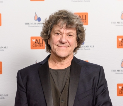 Man with black suit and black vest posing for camera