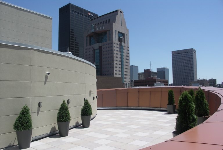 A large curved patio balcony area with small topiary in pots