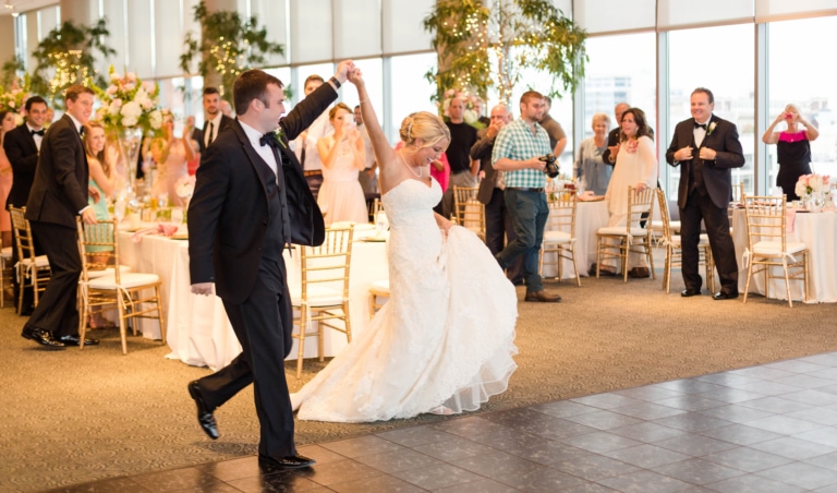 Bride and groom walking in to a wedding reception
