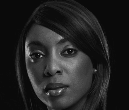 Black and white photo of woman with black blouse posing for camera